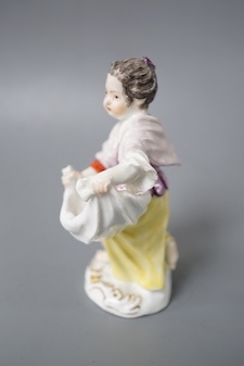 An 18th century Meissen figure of a girl holding her apron to make a basket shape kneeling on the mound scroll moulded base, small crossed swords in blue on the backside of the base. 9.5cm